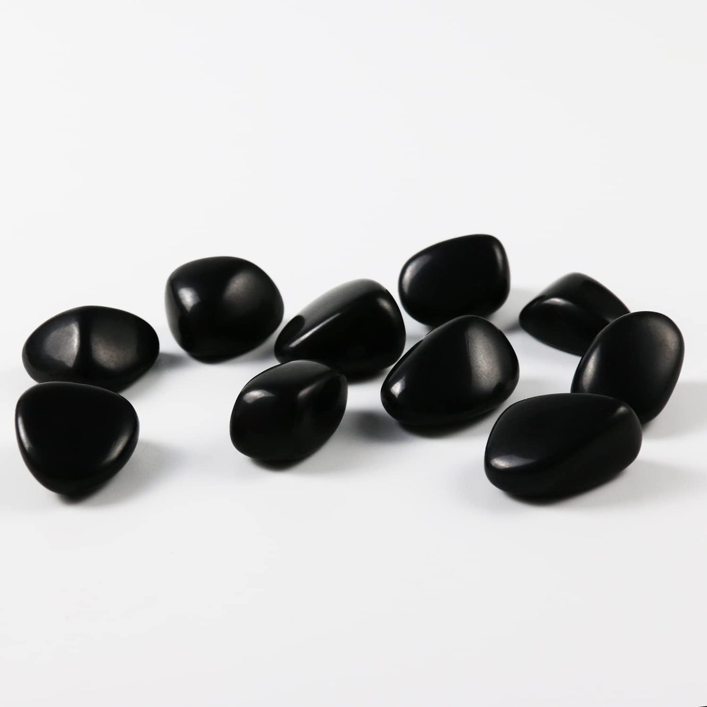 High-polish black obsidian tumbled stones for Feng Shui protection and root chakra grounding